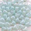 Vista de cuentas de corazón acrílicas azul claro de 10mm con efecto iridiscente para manualidades DIY. - 10mm Corazón Luminoso / Aprox. 1170 Pzas / Azul Claro / Luminoso