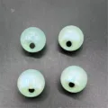 Gros plan de perles vert clair phosphorescentes à trou latéral pour créer des bijoux DIY. - 16mm 204pcs Paquet / Vert clair