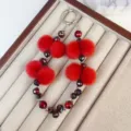 Red plush pom pom crystal beaded phone charm luxury cute keychain strap detail close up view - Red