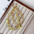 Detail view of crystal beaded phone chain and bag charm with gold alloy and lucky pendants. - Layered Gold