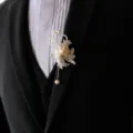 Detailed close-up of a white lace pearl boutonniere pin elegantly styled on a black suit lapel. - Corsage / White