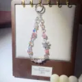 Detailed view of crystal beaded phone charm with alloy bow, sparkling pink and iridescent. - Pink