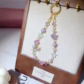 Handmade beaded phone strap with purple pearls and crystal star pendants, exquisite detail shot. - Starfish Style / Purple