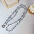 Crystal beaded phone strap detail, blue holographic flower charm and metal ring connector. - Crossbody-Blue