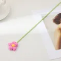 Fleur bouffante en laine tricotée à la main avec tige verte pour décoration de bureau. - Violet