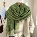 Dettaglio in primo piano della sciarpa invernale a quadretti verdi drappeggiata beige. - Verde (Griglia Bianca)