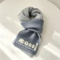 Vista dettagliata della sciarpa in maglia jacquard con pecora, comodo accessorio invernale. - Grigio