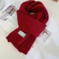 Dettaglio in primo piano di sciarpa in maglia rossa con trama morbida e design caldo. - rosso Natale