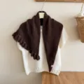 Scialle in maglia marrone con volant abbinato a maglione bianco a maniche corte, dettaglio. - Caffè