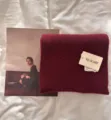 Soft burgundy knitted scarf detail shot showcasing cozy plush texture and branded paper tag. - Wine Red
