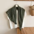 Charming dark green ruffled knit shawl detail, cozy cape style overlaying white top. - Dark Green