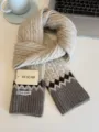 Detailed view of cozy cable knit winter scarf in beige with grey ribbed ends and pattern. - Apricot with Gray Edge