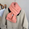 Primo piano dettagliato della morbida sciarpa in maglia rosa sopra un capo, tessuto caldo. - rosa ciliegia