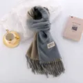 Close-up detail view of the double-sided cashmere-feel winter scarf with elegant fringes. - Sea Salt Blue