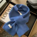 Vista dettagliata della sciarpa incrociata in lana blu, morbida trama a maglia, scalda collo. - Blu Reale