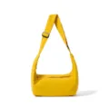 Detail view of a minimalist yellow shoulder bag with adjustable strap and zipper closure. - Yellow