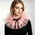 Detailansicht des rosa Tüll-Rüschenkragens mit schwarzer Schleife, feine Textur. - Rosa