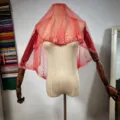 Gros plan sur le voile cape en tulle transparent bordeaux avec des perles fines et décorées. - Taille unique / Rouge Vif
