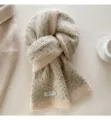 Vista dettagliata di una sciarpa in maglia di misto lana beige con elegante etichetta. - Colore avena