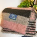 Primo piano di una sciarpa invernale soffice e a righe, morbida consistenza in misto lana. - A Righe Rosa e Caffè