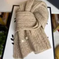 Primo piano dettagliato di una comoda sciarpa in lana beige a trecce, calda e morbida per l'inverno. - Colore avena