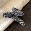 Détail de pince à cheveux tricotée noire et blanche, accessoire en laine texturée. - Pince en forme de Z / Noir et Gris