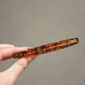 Detail view of the elegant tortoiseshell acetate hair clip with golden handmade lettering. - Blue Coffee Barrette
