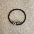 Detailed close-up view of a stylish acetate bow hair tie with chic pattern on texture background. - Black and White Bow
