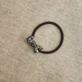 Dettaglio di un grazioso elastico per capelli con fiocco in acetato per lo styling quotidiano. - Nastri bianchi e neri