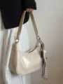 Chic beige patent leather shoulder underarm dumpling bag with decorative rope pendant detail. - Without Charm / White