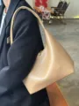 Close-up detail showing the texture of the stylish soft leather minimalist underarm bag. - Apricot