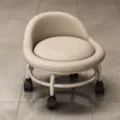 Beiger niedriger Hocker mit Rückenlehne gepolstert und Rollen für Zuhause und Büro ideal. - Gebrochenes Weiß