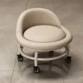 Moderner beiger, rollbarer Klein-Hocker mit weich gepolstertem Sitz und Universalrädern. - Weiß