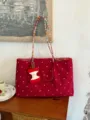 Red canvas tote bag detail, featuring colorful woven straps and a cute plush apple pendant. - With Charm / L / Red