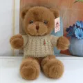 Detailed view of brown plush teddy bear wearing a beige knitted sweater with bee brooch. - Bee Brown Sweater Brown Bear / 30 cm
