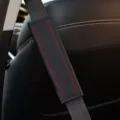 Black leather car seatbelt cover with red stitching and diamond embossed design for comfort. - 6.5x23cm / Black with Red Line