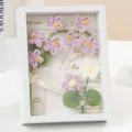 Scatola d'ombra di fiori di non-ti-scordar-di-me all'uncinetto cornice in legno vuota 3D. - Viola