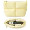 Detail view of the quilted cosmetic pouch showing its interior compartments and large storage capacity. - Light Yellow