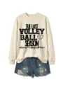 Detailansicht des beigen Sweatshirts mit Volleyball-Grafik und Jeansshorts im Set. - S / Sandfarbenes Sweatshirt (Schwarzes Textmuster)