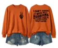 Casual women's orange long sleeve sweatshirt featuring front graphic and funny back text detail. - Burnt Orange (Black Graphic)