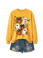 Detailansicht des niedlichen Halloween Geister Sweatshirts mit Kürbisprint und Jeansshorts. - Gelbes Sweatshirt (Schwarzes Textmuster)