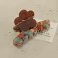 Detailed close-up of a stylish French acetate hair claw clip featuring a brown flower and colorful pattern. - Caramel-6cm