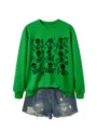 Close-up detail of green crewneck sweatshirt with cute skeleton graphic prints and bows. - S / Tops / Grass Green