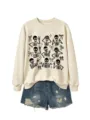 Detailed view of cream sweatshirt featuring playful black skeleton and bow graphics. - S / Tops / Sand