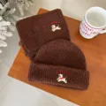 Detailed view of the cute brown knitted baby hat and scarf set with sweet puppy embroidery. - Set / Coffee