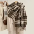 Detailed view of the soft brown plaid cashmere-feel scarf with elegant fringe and cozy texture. - Coffee