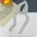 Vista dettagliata di una sciarpa lunga a pois neri e bianchi per stile versatile. - Pois Piccoli Bianco