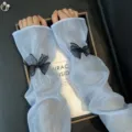 Gros plan détaillé de manches de protection solaire estivales bleu clair avec un nœud noir chic. - Taille unique / Manches en Maille à Noeud Noir - Bleu Lac