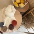 Vue de détail d'une écharpe tricotée élégante pour enfants avec pompons colorés, tour de cou chaud. - Écharpe Pom Pom J4-Blanc
