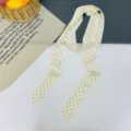 Vista dettagliata di un foulard lungo a pois color crema, accessorio elegante. - Stella Puntini Beige